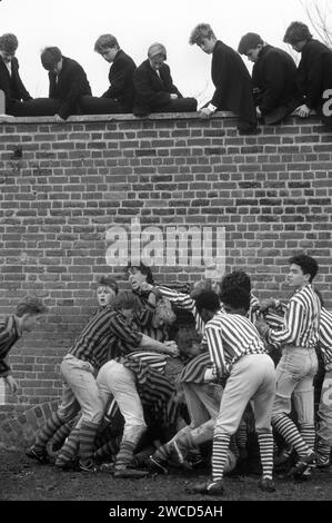 Eton College, vicino a Windsor, Berkshire. Eton scolari che giocano all'unico Wall Game annuale. Giocata annualmente a novembre, tra i collezionisti (King's Scholars - borsari) che affrontano gli oppidani (il resto della scuola). Anche se il College ha solo 70 ragazzi tra cui scegliere, rispetto ai circa 1250 oppidani. 1980s Regno Unito Foto Stock