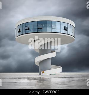 La torre del ristorante panoramico del Niemeyer Center con un uomo in giacca gialla all'ingresso delle scale in un giorno di pioggia, ad Aviles, Asturias, Spagna Foto Stock