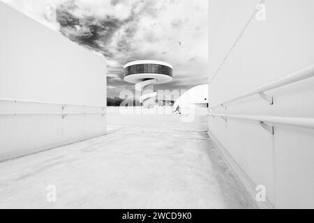 Fotografia in bianco e nero dell'architettura moderna con un corridoio nel Niemeyer Centre con uno skateboard per bambini, Aviles, Asturias, Spagna. Foto Stock