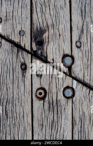 Una fotografia dettagliata in primo piano che mostra la texture degli agenti atmosferici e l'intricato motivo a grana di una tavola d'epoca in legno Foto Stock