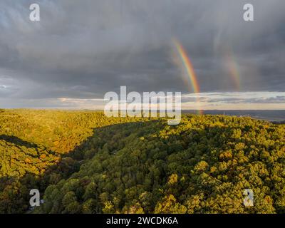 Un debole arcobaleno al tramonto sulla Coopers Rock State Forest con fogliame autunnale Foto Stock