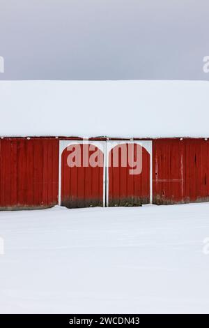 Fienile rosso con ingresso bianco ad arco dopo una tempesta di neve nella contea di Mecosta, Michigan, Stati Uniti [nessun rilascio di proprietà; solo licenze editoriali] Foto Stock