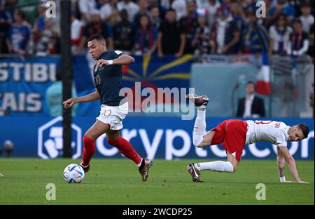 Kylian Mbappé dà il via a un giocatore polacco durante il turno dei 16 3-1 contro la Polonia nella Coppa del mondo del Qatar 2022. Foto Stock