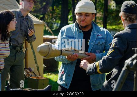 2023 - American Heritage Museum - Hudson, Massachusetts. Un uomo tiene in mano un lanciagranate con soldati di rievocazione della seconda guerra mondiale intorno a lui. Foto Stock