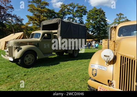 2023 - American Heritage Museum - Hudson, Massachusetts. I veicoli da trasporto dell'era della seconda guerra mondiale parcheggiano nell'erba in occasione di un evento di rievocazione. Foto Stock