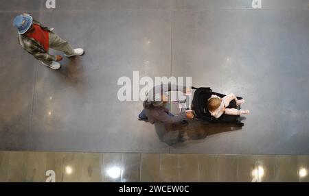 Vista dall'alto di una donna che spinge un bambino in un passeggino - novembre 2023 Foto Stock
