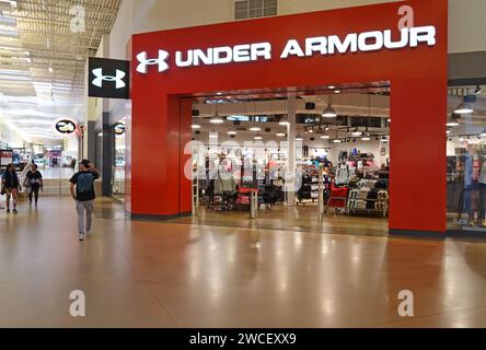 Gen Z Young Man che cammina in un negozio Under Armour nel centro commerciale Grapevine Mills - novembre 2023 Foto Stock