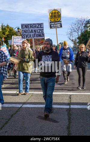 Un uomo con una t-shirt Black Lives Matter porta un cartello in centro come parte di un evento di vacanza Dr. Martin Luther King Jr.. Foto Stock