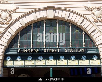 Vista frontale ravvicinata del cartello con il nome e degli orologi sopra l'ingresso principale della stazione di Flinders Street a Melbourne, Victoria, Australia. Foto Stock