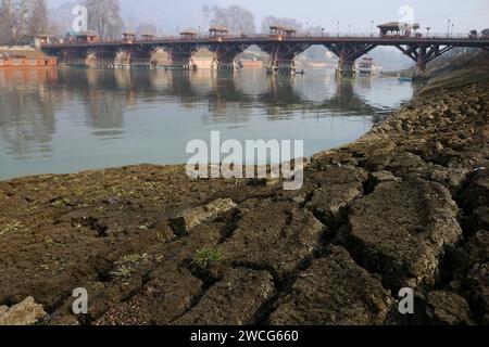 Srinagar Kashmir, India. 15 gennaio 2024. Vista di una porzione secca del fiume Jhelum a Srinagar. Un lungo periodo invernale secco lascia il fiume Jhelum a Historic Low, mettendo a rischio le case galleggianti e deludenti sciatori a Gulmarg. Il 15 gennaio 2024, Srinagar Kashmir, India. (Immagine di credito: © Firdous Nazir/eyepix via ZUMA Press Wire) SOLO USO EDITORIALE! Non per USO commerciale! Foto Stock