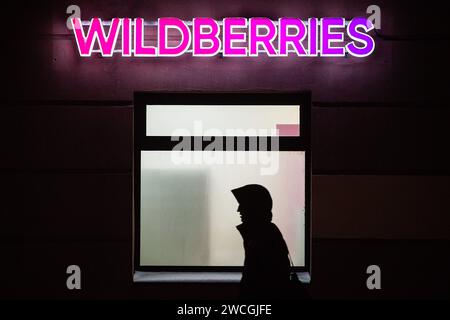 St Pietroburgo, Russia. 15 gennaio 2024. Un uomo cammina davanti a uno dei punti di consegna Wildberries la sera a San Pietroburgo. Un incendio e' iniziato al magazzino Wildberries a Shushary in St. Pietroburgo la mattina del 13 gennaio. Il Ministero delle situazioni di emergenza ha localizzato l'incendio su un'area di 70 mila metri quadrati. Gli esperti stimano che l'ammontare dei danni sia compreso tra 10 e 20 miliardi di rubli. Wildberries ha già annunciato che intende pagare un indennizzo ai venditori per i beni smarriti. Credito: SOPA Images Limited/Alamy Live News Foto Stock