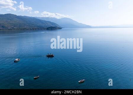 Una barca di piacere sul lago di Ocrida, nella Macedonia del Nord, vicino alla città di Ocrida, con una vista mozzafiato sulle acque blu del lago in una giornata di sole. Foto Stock