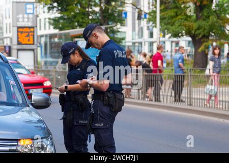 Breslavia, Polonia - 05 giugno 2019: Due agenti di polizia danno un biglietto a un autista. Foto Stock