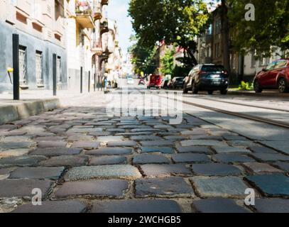 Primo piano delle pietre di pavimentazione su una vecchia strada illuminata dalla luce del sole. Contesto Foto Stock