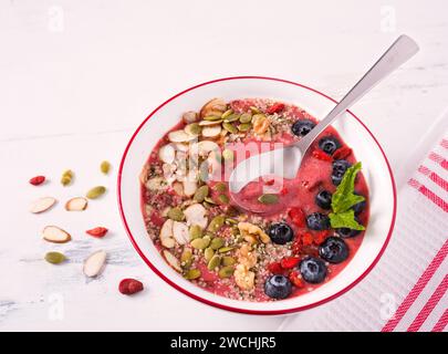 Recipiente per frullati sani con mirtilli, noci, semi di canapa, mandorle a fette e semi di zucca Foto Stock