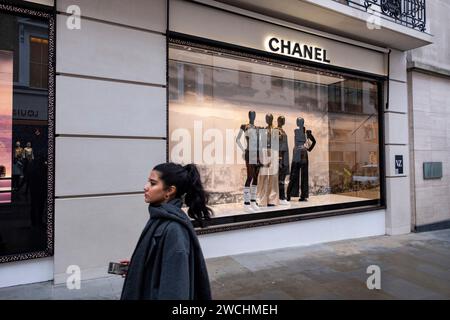 Figure di persone interagiscono con i manichini nella vetrina del negozio Chanel in Bond Street il 4 dicembre 2023 a Londra, Regno Unito. Bond Street è una delle strade principali del quartiere dello shopping del West End ed è molto esclusiva. E' stata una strada alla moda per lo shopping fin dal XVIII secolo. Il ricco e ricco negozio qui, soprattutto di alta moda e gioielleria. Foto Stock