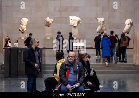 Sculture del Partenone dell'Antica Grecia, frammenti che sono collettivamente conosciuti come i Marmi del Partenone alias Marmi di Elgin al British Museum, che è molto frequentato dai visitatori il 4 dicembre 2023 a Londra, Regno Unito. I marmi di Elgin sono considerati beni rubati dalla Grecia, e ne ha regolarmente richiesto il ritorno, mentre il Museo dell'Acropoli, che ospita le sculture rimanenti, mantiene uno spazio vuoto per loro all'interno della sua attuale esposizione. Il museo britannico contrasta questo, sostenendo che le sculture sono state legalmente acquisite da Lord Elgin in seguito ad un accordo con i leader ottomani. Il Brit Foto Stock