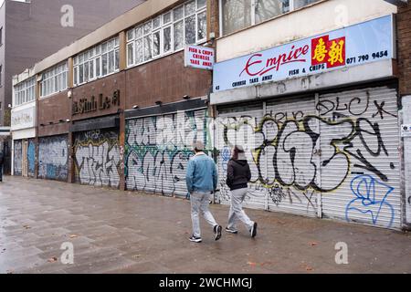 Una serie di piccole imprese chiuse con persiane lungo Mile End Road il 5 dicembre 2023 a East London, Regno Unito. Le cose sono state difficili per le piccole imprese negli ultimi due anni e soprattutto ora, con la crisi dei costi di vita in corso e le crescenti pressioni finanziarie sul costo dei beni, in cui i prezzi di molti beni essenziali nel Regno Unito hanno iniziato ad aumentare più rapidamente dei redditi delle famiglie, con conseguente calo dei redditi reali. Ciò è causato in parte da un aumento dell'inflazione nel Regno Unito, nonché dall'impatto economico delle questioni estere. Foto Stock