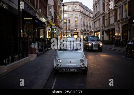 Un'auto d'epoca Fiat 500 è parcheggiata in Maddox Street a Mayfair, guardando verso Regent Street, Londra, Inghilterra, Regno Unito Foto Stock