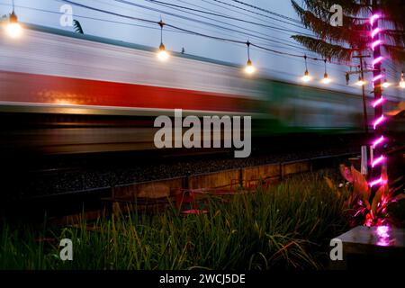 Il treno passeggeri si muove velocemente al tramonto Foto Stock