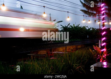 Il treno passeggeri si muove velocemente al tramonto Foto Stock