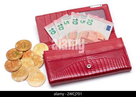 Aperto Red Women Purse con 10 Euro banconote all'interno e Bitcoin Coins - isolato su sfondo bianco. Un portafoglio pieno di soldi che simboleggia ricchezza, successo, shopping e status sociale - isolamento Foto Stock