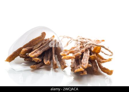 Una manciata di carne di pollo secca, marinata con spezie, isolata su sfondo bianco. Spuntino speziato con birra. Foto Stock