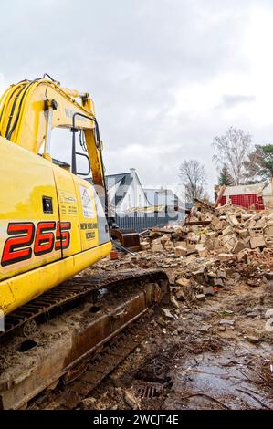 Berlino, Germania - 20 febbraio 2022: Un escavatore si trova in un cantiere dove viene demolito un vecchio edificio residenziale. Foto Stock