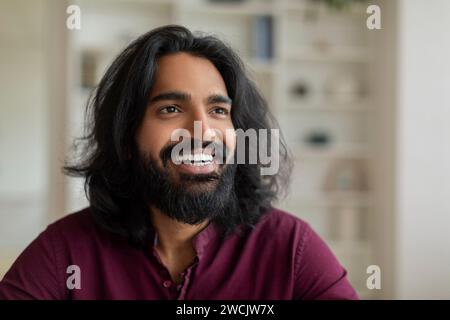 Ritratto di bel giovane indiano maschio che guarda da parte e sorride Foto Stock