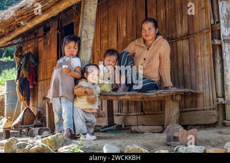 Madre Khmu con tre figli fuori dal loro rifugio in Laos Foto Stock