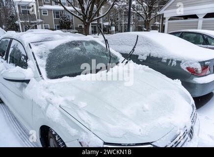Auto coperte di neve nel parcheggio di un complesso di appartamenti Foto Stock