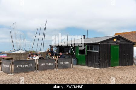 La gente che mangia al fast fish food tradizionale ristorante locale nel molo di Whitstable Harbour, Whitstable è famosa per le sue ostriche native. Foto Stock