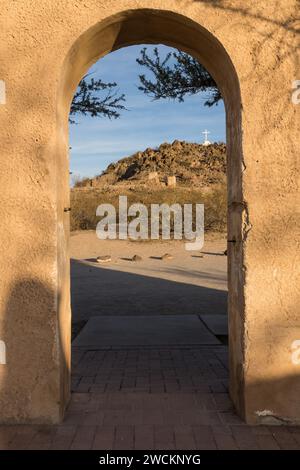 Porta ad arco attraverso il muro di protezione intorno alla missione San Xavier del Bac incornicia la Grotto Hill, Tucson Arizona. Foto Stock