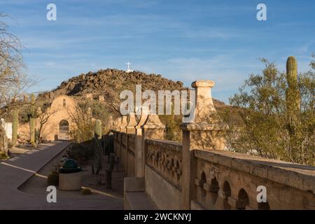 Porta ad arco attraverso il muro di protezione intorno alla missione San Xavier del Bac, Tucson, Arizona. Dietro c'è la collina della Grotta con la sua croce bianca. Foto Stock