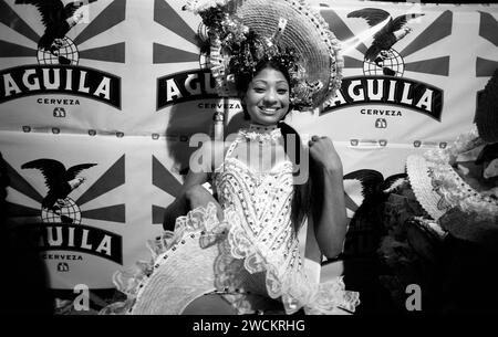 Spettacolari fotografie in bianco e nero del concorso annuale di bellezza Miss Colombia della popolazione locale a Cartagena, Colombia, i concorrenti afro-colombiani rappresentano i quartieri poveri della città. Le ragazze indossano elaborati costumi fatti in casa e copricapi di piume e sfilano le strade secondarie di Cartagena dopo il tramonto. Foto Stock