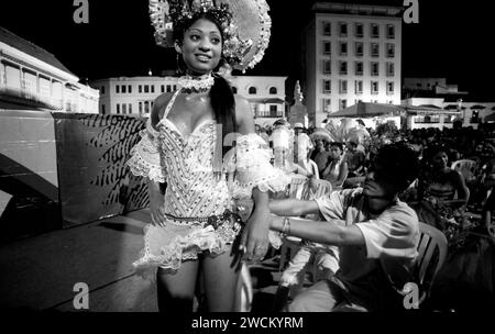 Spettacolari fotografie in bianco e nero del concorso annuale di bellezza Miss Colombia della popolazione locale a Cartagena, Colombia, i concorrenti afro-colombiani rappresentano i quartieri poveri della città. Le ragazze indossano elaborati costumi fatti in casa e copricapi di piume e sfilano le strade secondarie di Cartagena dopo il tramonto. Foto Stock