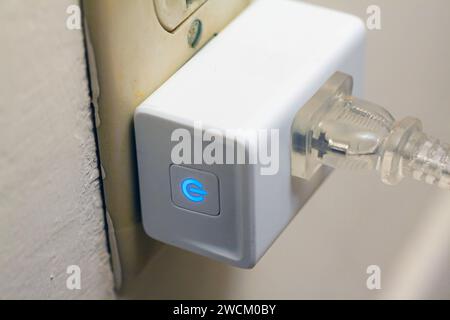 Smart plug collegato a una presa elettrica Foto Stock