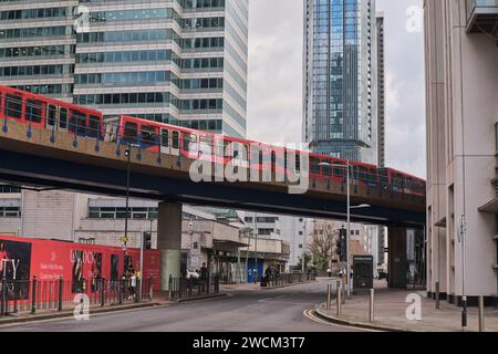 Docklands Light Railway (DLR), che passa sopra la testa, serpeggiando attraverso South Quay, Canary Wharf, Londra Foto Stock