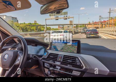 Vista dall'interno mobile dell'auto elettrica BMW iX3 sull'autostrada con altri veicoli sulle strade di Stoccolma. Svezia. Foto Stock