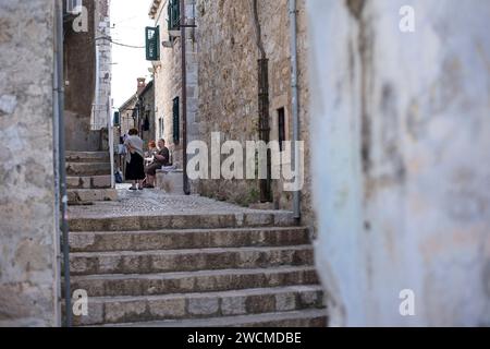 Dubrovnik, Croazia - 10 ottobre 2019: La gente del posto si impegna a conversare sui gradini di pietra di un vicolo tranquillo nel cuore storico di Dubrovnik, Croati Foto Stock