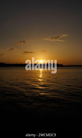 Tramonto sul fiume Maroni con una barca Foto Stock