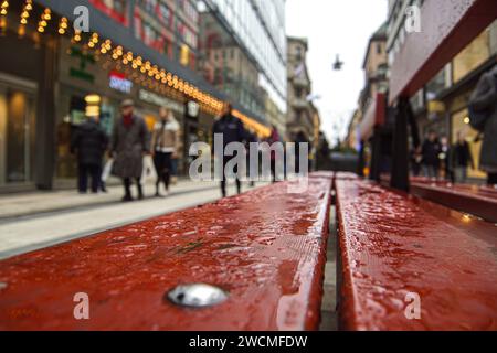 Primo piano di una panchina di strada durante il tempo piovoso Foto Stock