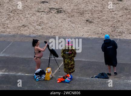 Donna incinta in bikini su una spiaggia fredda a gennaio Foto Stock