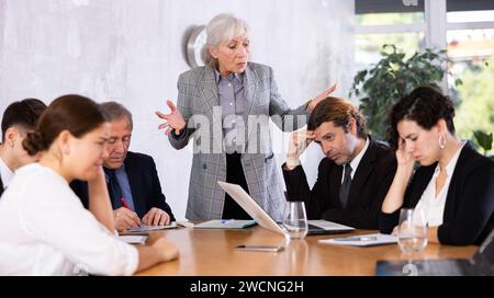 Irritato anziano boss donna rimproverare i subordinati in carica Foto Stock