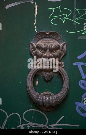 Vecchio battito, testa e anello su una porta d'ingresso, centro storico, Genova, Italia Foto Stock