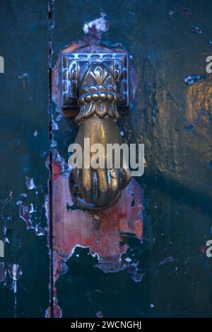 Mano di bronzo come battente di porta su una porta d'ingresso nel centro storico di Genova, Italia Foto Stock