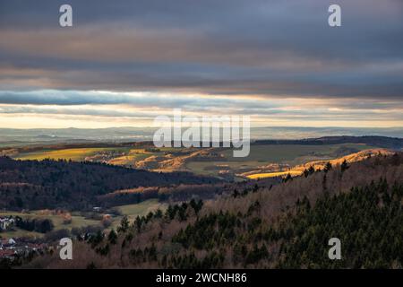 Paesaggio presso il Grosser Zacken, regione vulcanica del Taunus. Una giornata d'autunno nuvolosa e soleggiata, prati, colline, campi e foreste con vista del tramonto. Foto Stock