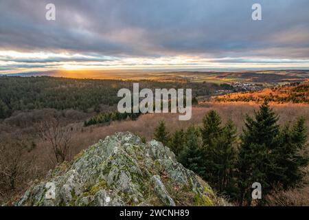 Paesaggio presso il Grosser Zacken, regione vulcanica del Taunus. Una giornata d'autunno nuvolosa e soleggiata, prati, colline, campi e foreste con vista del tramonto. Foto Stock