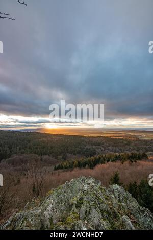 Paesaggio presso il Grosser Zacken, regione vulcanica del Taunus. Una giornata d'autunno nuvolosa e soleggiata, prati, colline, campi e foreste con vista del tramonto. Foto Stock