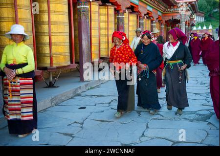 Tibet, Kham, Litang. Nomadi tibetani vicino a Litang. Gente che circonda il monastero con le ruote di preghiera. Foto Stock